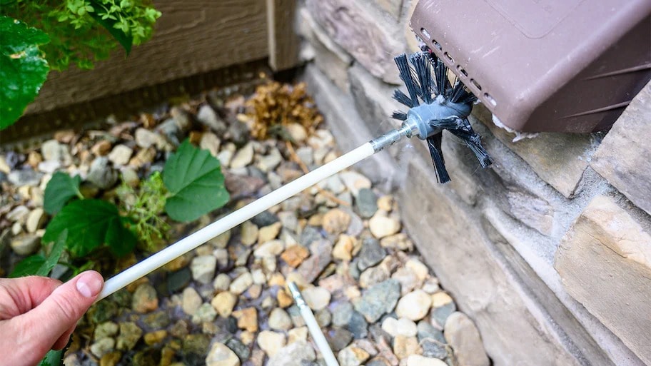 person cleaning dryer vent with brush